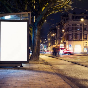 Outdoor advertising billboard or abri kiosk at nighttime in the city